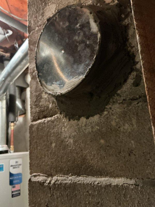 Completed repair of basement chimney duct system. The metal vent pipe penetration through the concrete block wall was serviced, addressing accumulated soot and deterioration issues. All work performed according to quoted specifications with photo documentation provided.