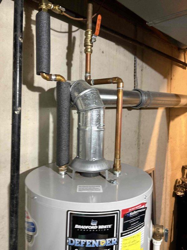 Responded to no hot water complaint on 14-year-old Bradford White water heater. Upon arrival, inspected unit and plumbing connections. Water heater was not producing hot water at any temperature setting. Documented existing installation including copper supply lines, brass shutoff valves, expansion tank, and insulated piping configuration. Photographed water heater setup and surrounding mechanical room conditions for service records.