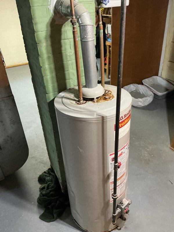 Responded to customer request for water heater replacement quote. Inspected existing gas-fired water heater located in basement utility area, noting unit age unknown per customer. Documented current installation including venting configuration with galvanized vent pipe, copper supply lines with shutoff valve, and connection points. Observed visible corrosion and rust staining at tank base connections indicating potential minor leakage or condensation issues over time. Photographed equipment, piping assembly, and installation conditions for estimate preparation. Provided quote for water heater replacement.