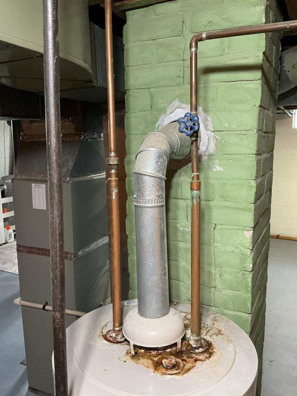 Responded to customer request for water heater replacement quote. Inspected existing gas-fired water heater located in basement utility area, noting unit age unknown per customer. Documented current installation including venting configuration with galvanized vent pipe, copper supply lines with shutoff valve, and connection points. Observed visible corrosion and rust staining at tank base connections indicating potential minor leakage or condensation issues over time. Photographed equipment, piping assembly, and installation conditions for estimate preparation. Provided quote for water heater replacement.