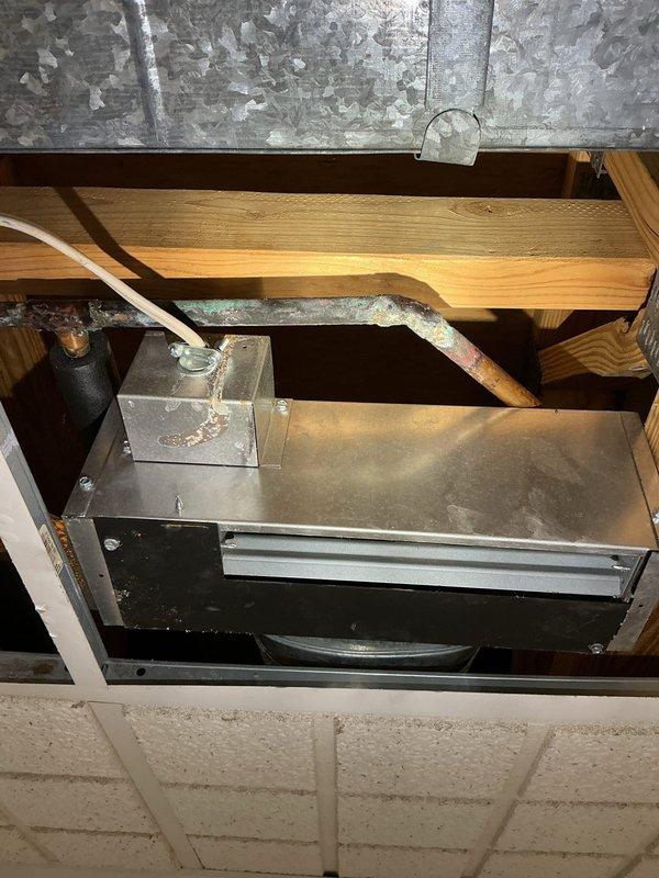 Responded to emergency water leak in guest bedroom ceiling with active steady stream from multiple points. Upon arrival, hot water supply had been shut off by occupant to stop flow. Accessed ceiling cavity through drop ceiling tiles and inspected affected area. Located source of leak in ceiling space above HVAC air handler unit. Documented conditions showing water intrusion around plumbing infrastructure, including PVC piping running through wooden structural framing and joists. Photographed HVAC equipment, ductwork, and surrounding building components to assess extent of water damage and identify leak origin. Inspected metal ductwork, copper refrigerant lines, and ceiling cavity structural members for water damage and compromised integrity. Provided client with documentation of findings and recommendations for necessary repairs to resolve active leak condition.