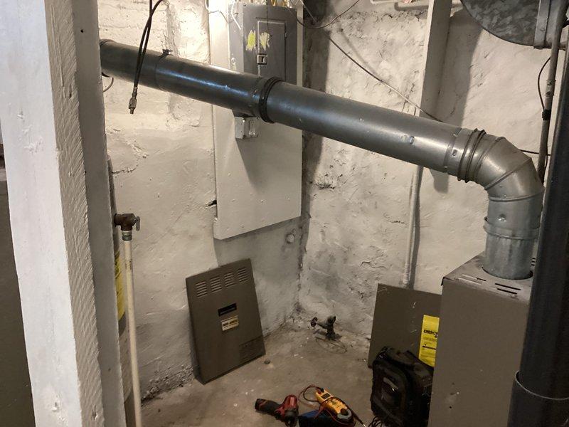 Completed rental inspection of vacant property's mechanical systems, including one furnace and one water heater located in basement utility area. Documented condition of HVAC equipment, ductwork, ventilation systems, and water heating unit through photographic inspection, noting all visible piping, electrical connections, and exhaust venting installations for property records.