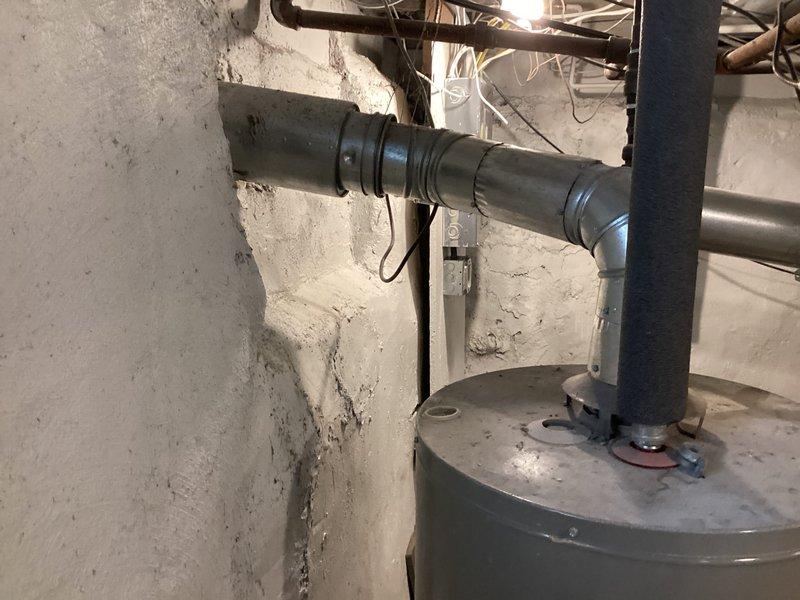 Completed rental inspection of vacant property's mechanical systems, including one furnace and one water heater located in basement utility area. Documented condition of HVAC equipment, ductwork, ventilation systems, and water heating unit through photographic inspection, noting all visible piping, electrical connections, and exhaust venting installations for property records.
