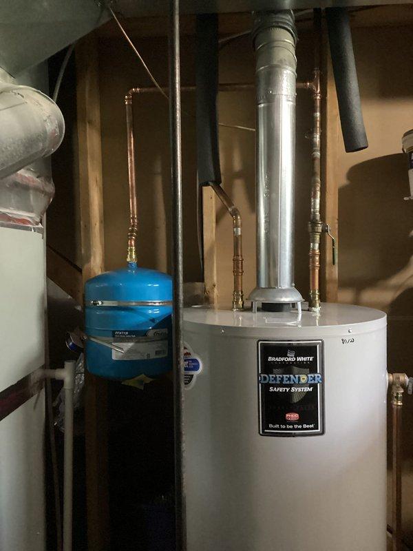 Returned to property to complete installation of expansion tank on water heating system. Installed thermal expansion tank with proper copper piping connections and brass fittings to accommodate thermal expansion in closed water system. Verified proper mounting and pressure settings on expansion tank to protect Bradford White water heater and household plumbing fixtures. Tested system operation and confirmed no leaks at connection points.