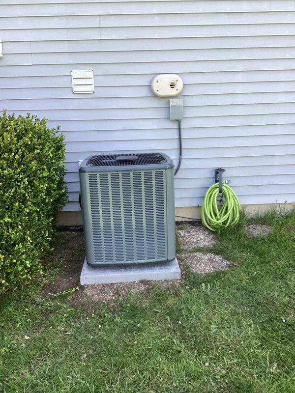 Completed full system replacement of residential HVAC equipment including furnace and air conditioning unit. Installed new Energi Force Center furnace in basement mechanical room with proper condensate drainage via white PVC piping and connected metal supply ductwork. Installed new outdoor AC condenser unit on concrete pad against exterior wall with gray-green finish, positioned electrical disconnect box on wall with conduit connection, and verified proper refrigerant line connections. All equipment tested and operational upon completion, with system ready for service.