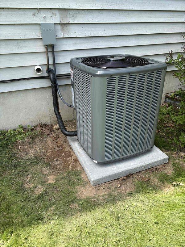 Completed full HVAC system installation including new furnace unit in basement mechanical room and outdoor condensing unit. Installed furnace with proper PVC venting and condensate drainage, mounted outdoor condenser on concrete pad with refrigerant line set and electrical conduit connections run along exterior wall. Installation pending final electrical connection before system commissioning.