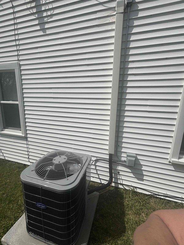 Completed full air conditioning system installation including indoor air handler unit and outdoor condenser unit. Installed new gray furnace/air handler in interior utility room with proper refrigerant line connections, electrical conduit, and flexible ductwork routing. Mounted outdoor condenser unit on pad adjacent to building exterior with electrical whip connection secured to siding. Verified all refrigerant lines, electrical connections, and condensate drainage properly installed and operational. System tested and confirmed cooling operation.