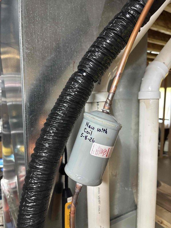 Replaced evaporator coil on residential HVAC system. Installed new coil assembly with proper refrigerant line connections, secured exterior line set with foam insulation and mounting straps, and labeled component with installation details. System tested and operational upon completion.