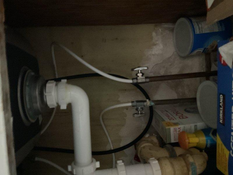 Performed comprehensive assessment of non-functioning water heater in basement utility area. Documented existing white cylindrical water heater with connected copper piping, brass fittings, and shut-off valves showing signs of age and wear. Evaluated plumbing infrastructure including horizontal copper supply lines, elbow joint configurations, and overall system condition in deteriorated mechanical room environment. Provided estimate for water heater replacement and necessary plumbing modifications.