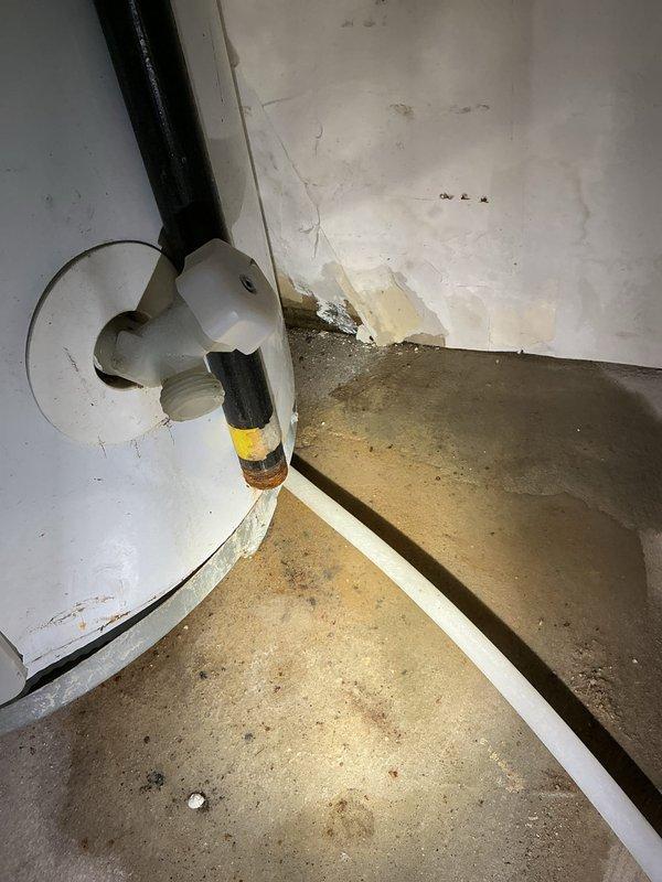 Responded to service call for leaking water heater in basement utility room. Upon inspection, identified active leak originating from water heater tank connections. Assessed copper piping, isolation valves, and mounting configuration. Documented existing conditions including moisture damage and wall discoloration behind unit, indicating prolonged leak exposure. Captured photographic evidence of mechanical room layout, HVAC equipment proximity, and water heater installation for service records. Recommended water heater replacement due to age and extent of deterioration observed at connection points and tank integrity concerns.