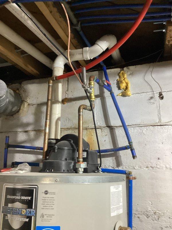 Responded to no hot water complaint at residential property. Upon arrival, inspected Bradford White Defender water heater and associated plumbing connections in basement utility area. Performed diagnostic troubleshooting on water heater unit, examined gas supply line with yellow shutoff valve, verified copper and PEX water supply lines, and inspected venting system with white PVC components. Identified and resolved issue preventing hot water production. Unit restored to proper operation and tested for adequate hot water delivery throughout system.