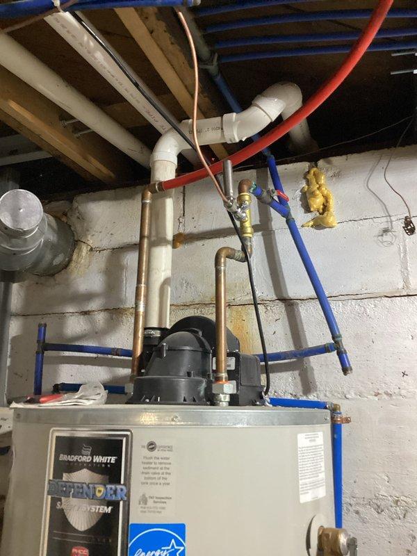 Responded to no hot water complaint at residential property. Upon arrival, inspected Bradford White Defender water heater and associated plumbing connections in basement utility area. Performed diagnostic troubleshooting on water heater unit, examined gas supply line with yellow shutoff valve, verified copper and PEX water supply lines, and inspected venting system with white PVC components. Identified and resolved issue preventing hot water production. Unit restored to proper operation and tested for adequate hot water delivery throughout system.