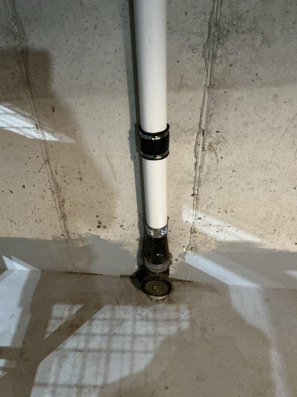 Responded to main line sewer backup in basement area. Upon arrival, located cleanout access point at base of vertical PVC drain stack secured to concrete block wall. Deployed mechanical cable snake through cleanout to clear obstruction in main sewer line. Successfully removed blockage and restored proper drainage flow. Tested system to verify complete clearance and proper operation of drain system.