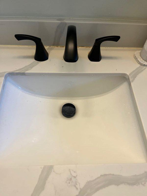 Successfully installed customer-supplied matte black kitchen faucet with dual handles and matching tub spout in bathroom to coordinate with existing design aesthetic. All fixtures were properly mounted, connected to existing water supply lines, tested for leaks, and confirmed fully operational with proper water flow and drainage.