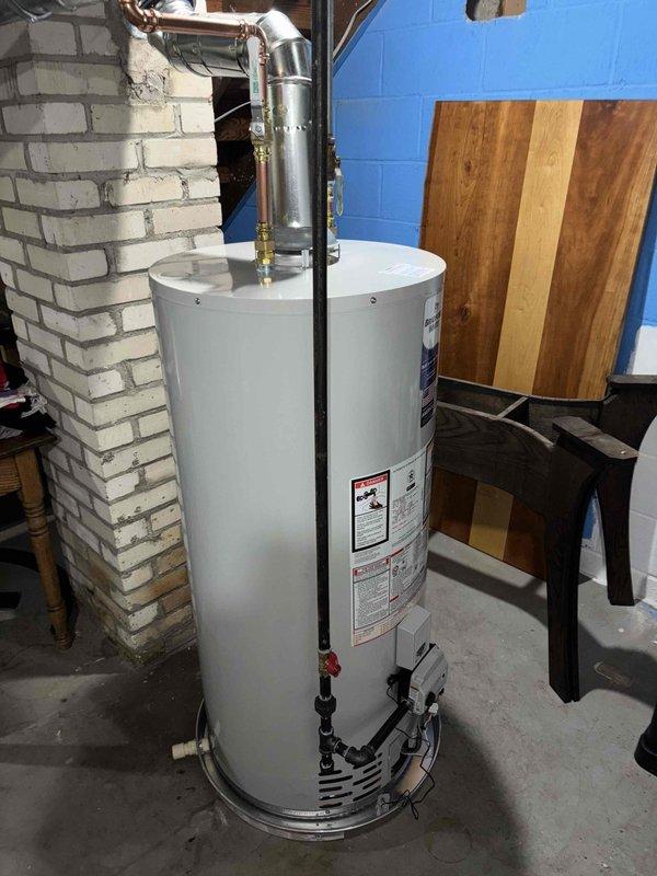 Successfully installed a 40-gallon Bradford White natural gas water heater in basement utility area. Connected copper supply piping, gas line, and metallic flue vent system to manufacturer specifications. Positioned unit on concrete floor with proper clearances for maintenance access and code compliance. Verified all connections for proper operation and safety.