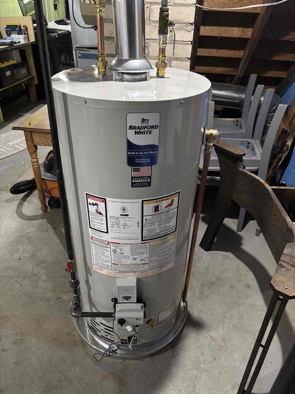 Successfully installed a 40-gallon Bradford White natural gas water heater in basement utility area. Connected copper supply piping, gas line, and metallic flue vent system to manufacturer specifications. Positioned unit on concrete floor with proper clearances for maintenance access and code compliance. Verified all connections for proper operation and safety.