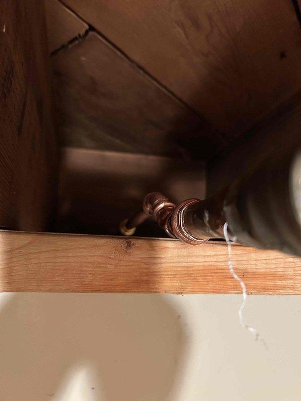 Responded to plumbing leak call initially reported as HVAC-related but determined to be caused by frozen and broken exterior spigot. Accessed shower valve assembly through wall opening to diagnose hot water delivery issue, inspecting valve stem, mounting hardware, and connection points. Documented condition of plumbing fixtures and identified frozen pipe damage as primary cause of leak, unrelated to water heater system.