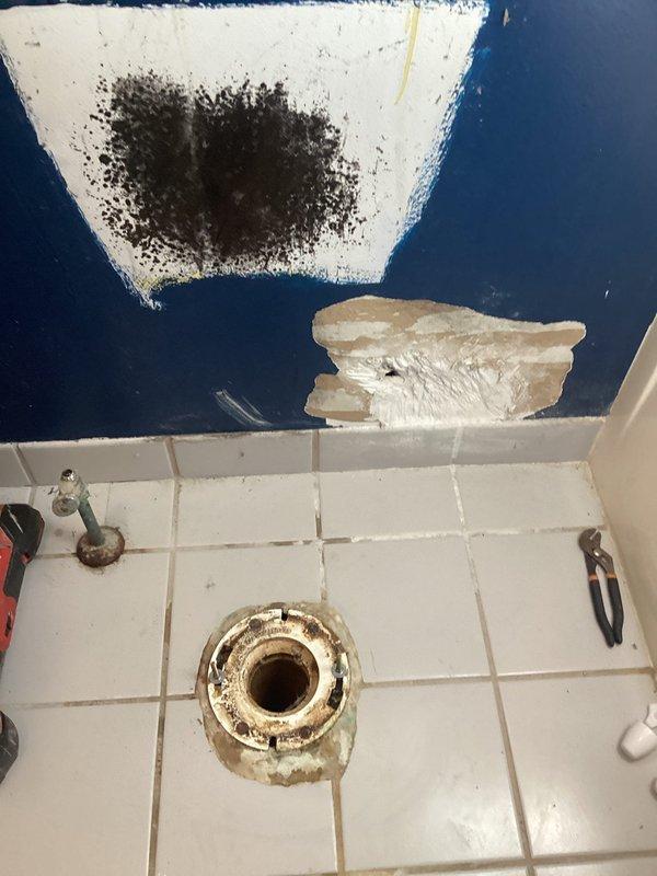 Responded to toilet tank not holding water. Upon inspection, found deteriorated internal flush mechanism components with significant rust and mineral deposits throughout tank interior. Removed tank lid and assessed fill valve, flush valve, and float assembly. Identified failed flapper valve as primary cause of continuous water loss. Replaced worn flapper and inspected tank-to-bowl seal for integrity. Noted evidence of long-term water damage on adjacent bathroom wall and floor, including visible staining and deterioration. Tested flush cycle and verified proper water retention after repairs. System restored to normal operation.