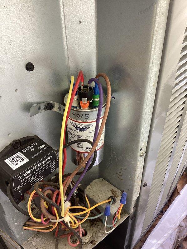 Completed annual cooling maintenance on 9-year-old Goodman air conditioning system. Inspected electrical components including dual-run capacitor (40/5 MFD) and CoreSense diagnostic module, verified all wire connections secure, checked condensate drain system with drip pan, and confirmed unit operational. All components functioning within normal parameters.