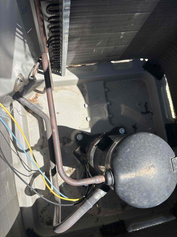 Responded to service call for air conditioning system tripping breakers and rendering entire home without cooling. Upon arrival, inspected six-year-old outdoor condensing unit and found excessive dirt and debris accumulation on condenser coil and protective grille, restricting airflow and causing compressor to overwork and trip electrical breakers. Observed oxidation on copper refrigerant lines consistent with unit age and outdoor exposure. Cleaned condenser coil and grille to restore proper airflow, verified electrical connections and compressor operation, tested system functionality, and confirmed unit cycling properly without tripping breakers. System restored to normal operation with adequate cooling capacity throughout home.