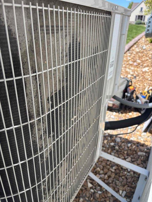 Responded to service call for air conditioning system tripping breakers and rendering entire home without cooling. Upon arrival, inspected six-year-old outdoor condensing unit and found excessive dirt and debris accumulation on condenser coil and protective grille, restricting airflow and causing compressor to overwork and trip electrical breakers. Observed oxidation on copper refrigerant lines consistent with unit age and outdoor exposure. Cleaned condenser coil and grille to restore proper airflow, verified electrical connections and compressor operation, tested system functionality, and confirmed unit cycling properly without tripping breakers. System restored to normal operation with adequate cooling capacity throughout home.