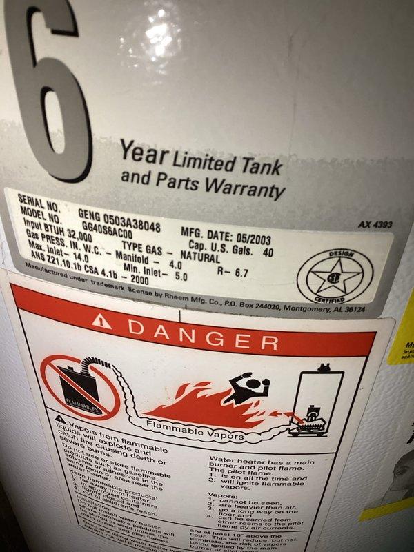 Provided estimate for replacement of 40-gallon natural gas water heater manufactured in May 2003 that is actively leaking from the base. Unit has exceeded its 6-year limited warranty period and shows significant age-related deterioration requiring full replacement rather than repair.