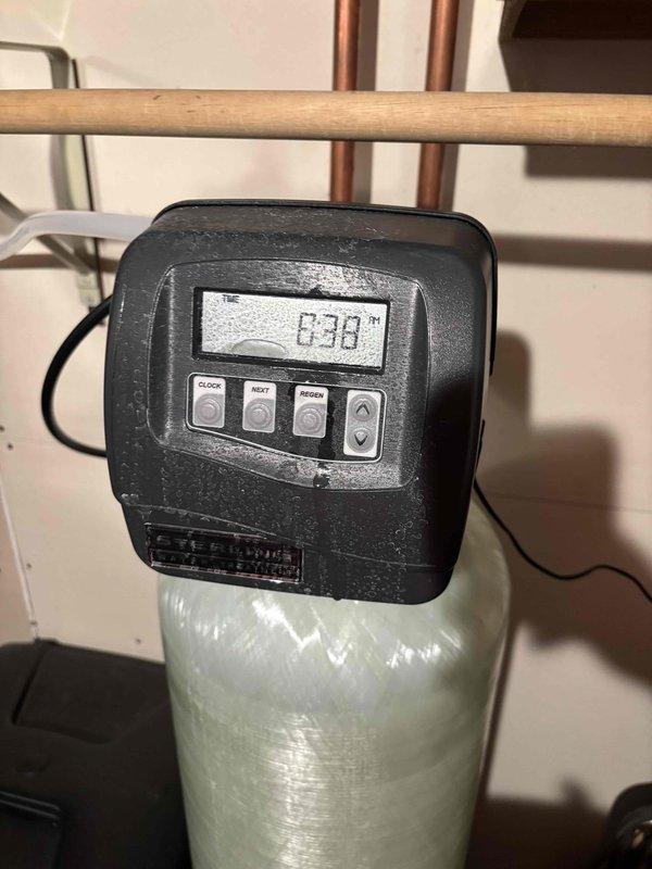 Responded to follow-up service call for persistent water softener leak that remained unresolved after previous plumbing visit. Upon arrival, inspected water softener system with digital control head displaying operational status, along with associated copper supply piping and connections in utility room adjacent to Rinnai tankless water heater installation. Identified source of leak, performed necessary repairs to water softener plumbing connections and fittings, and verified system integrity. Tested all connections under pressure to confirm leak was eliminated. Documented installation with photos showing water softener control unit, piping configuration, and surrounding mechanical systems for service records.