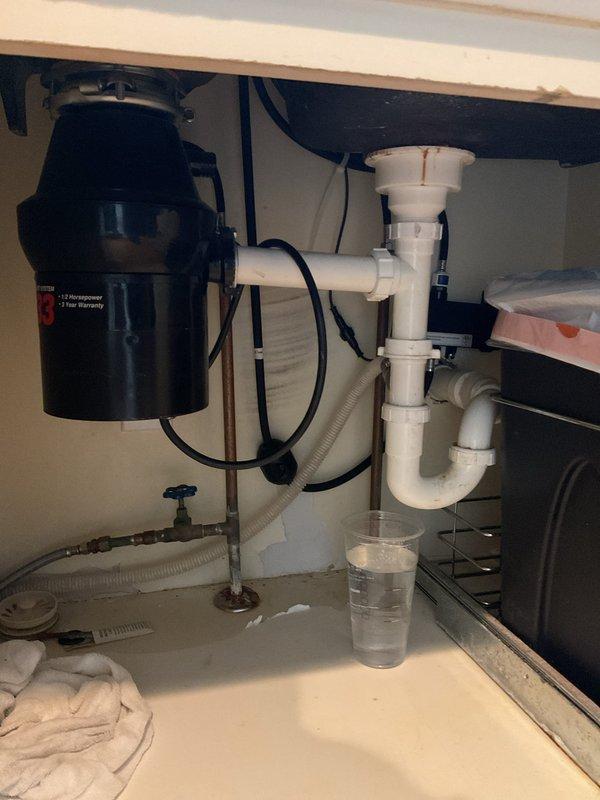 Responded to plumbing leak emergency at residential property. Upon arrival, assessed kitchen sink leak originating from faucet area and shut-off valve beneath sink. Inspected under-cabinet plumbing configuration including garbage disposal unit, P-trap assembly, and supply lines. Placed collection container to monitor active leak and prevent water damage to cabinet interior. 

Proceeded to basement bathroom where additional sink repair was required. Evaluated wall-mounted plumbing fixtures and supply lines. Positioned collection bucket beneath exposed piping to contain water flow during assessment and repair process. Completed necessary repairs to both kitchen and basement bathroom plumbing systems, restoring proper function and eliminating leaks at all affected fixtures.