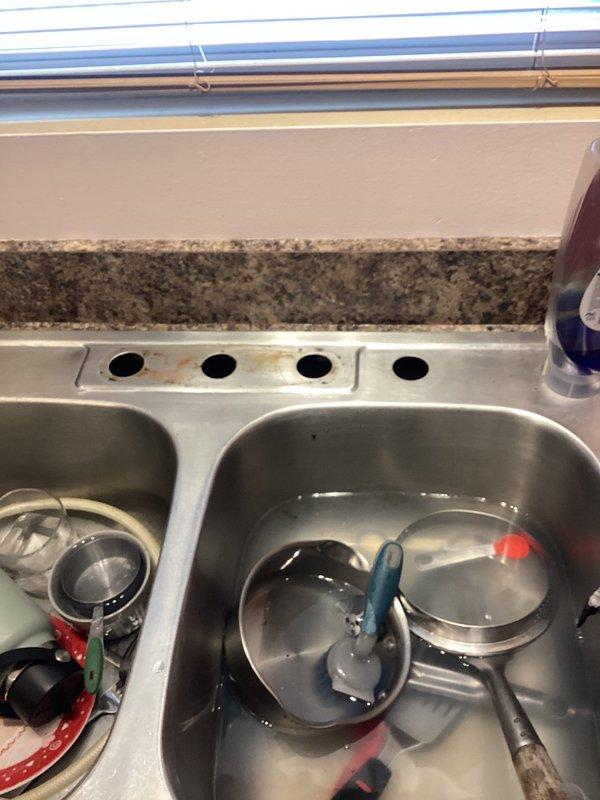 Installed new kitchen faucet assembly in double-basin stainless steel sink, removing existing fixture and connecting supply lines to complete installation. Customer's kitchen now features updated pull-down faucet with proper water flow and functionality, replacing previous fixture that required service.
