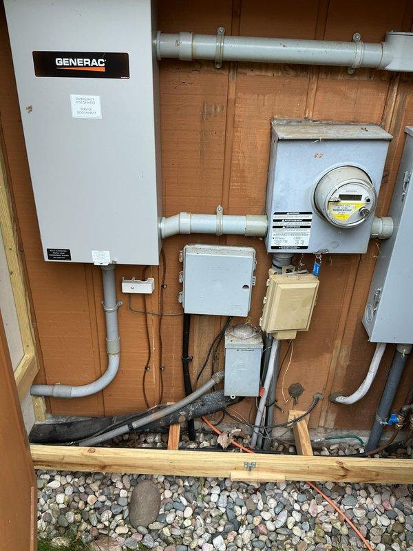 Completed annual cooling system tune-up and inspection on 37-year-old outdoor air conditioning condenser unit. Performed comprehensive maintenance protocol including visual inspection, coil cleaning, electrical connections check, refrigerant level assessment, and operational testing. Unit shows significant age-related weathering with extensive rust discoloration on top panel surfaces, though system remains functional. Verified proper operation of condenser fan motor, compressor function, and overall cooling performance. Documented equipment condition with photographic evidence showing installation alongside standby generator unit with proper clearances maintained. All electrical connections at exterior panel and meter box verified secure. System operating within acceptable parameters at time of service completion.