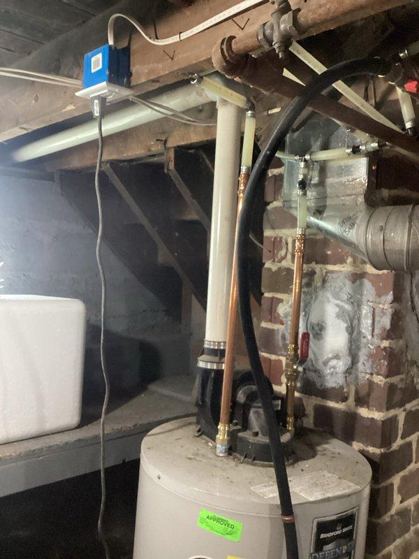 Responded to service call for 15-year-old Bradford White Defender water heater displaying "false pilot flame present" error message. Upon inspection, evaluated unit condition and verified error code. Documented existing installation including copper supply lines, flexible gas connections, and venting system. Assessed chimney and flue condition, noting significant deterioration of masonry with efflorescence, cracked mortar joints, and structural degradation that could impact proper venting function. Photographed water heater installation and compromised chimney structure for customer records. Advised customer of unit's age and overall condition, discussed repair versus replacement options given the existing infrastructure concerns and ongoing error condition. Provided professional recommendations for addressing both immediate water heater issue and deteriorated venting system to ensure safe operation.