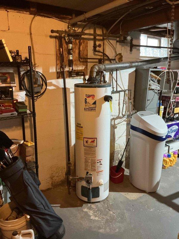 Completed estimate for tankless water heater installation to replace existing Richmond Integra 6 conventional tank-style water heater in basement utility area. Assessed current plumbing configuration including overhead copper piping, gas lines, venting requirements, and available space adjacent to existing water softener system, then documented site conditions and provided comprehensive quote for transitioning from traditional storage tank to on-demand tankless system.