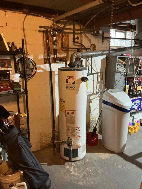 Completed estimate for tankless water heater installation to replace existing Richmond Integra 6 conventional tank-style water heater in basement utility area. Assessed current plumbing configuration including overhead copper piping, gas lines, venting requirements, and available space adjacent to existing water softener system, then documented site conditions and provided comprehensive quote for transitioning from traditional storage tank to on-demand tankless system.