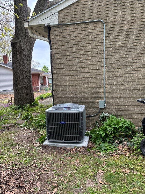 Completed full HVAC system installation including new air handler unit positioned in attic space with proper mounting and support structure. Installed Carrier brand outdoor condensing unit on concrete pad against exterior brick wall with secure placement and leveling. Routed flexible insulated ductwork throughout attic space connecting to air handler for proper air distribution, and installed refrigerant lines with electrical conduit running vertically along exterior wall to connect outdoor and indoor units. All components secured per manufacturer specifications and industry standards.