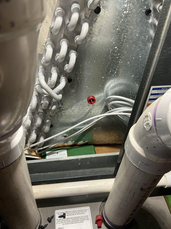 # AC Annual Cooling Visit - EnergiAir System

Completed annual cooling maintenance on 4-year-old EnergiAir system under warranty through June 2031. Upon inspection, discovered significant ice and frost accumulation on evaporator coil and internal metal panels, indicating restricted airflow or potential refrigerant charge issues. 

Performed comprehensive diagnostic evaluation to identify root cause of icing condition. Checked airflow through supply and return vents, which appeared clean and unobstructed with properly functioning louvers. Examined evaporator coil access panel revealing extensive crystalline frost buildup across central and right portions of coil surface with visible condensation and moisture droplets.

Assessed multiple potential causes including: restricted airflow from dirty filter or blocked return air path, low refrigerant charge, malfunctioning metering device, or blower motor operating below specification. Inspected refrigerant lines and connections for signs of l