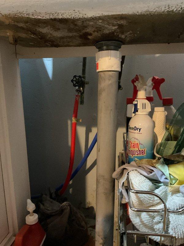 Responded to basement odor complaint originating from sink and floor drain area. Upon inspection, identified deteriorated ceiling materials with visible water damage and staining near plumbing infrastructure. Examined bathroom sink showing signs of wear and assessed utility area containing water heater with connected supply lines and vertical PVC drain pipe. Documented conditions of plumbing fixtures, drainage system components, and surrounding areas affected by moisture intrusion. Recommended addressing water damage to ceiling materials and ensuring proper trap seals in both sink and floor drain to eliminate sewer gas odors entering the living space.
