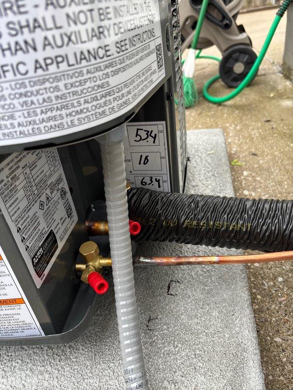 Completed full air conditioning system replacement at residential property. Removed existing outdoor condenser unit and installed new dark gray condensing unit on existing concrete pad against house exterior with proper clearances. Connected refrigerant lines through exterior wall penetration, installed electrical disconnect box, and completed all line set insulation and weatherproofing. System was charged, tested, and verified operational with all manufacturer specifications met.