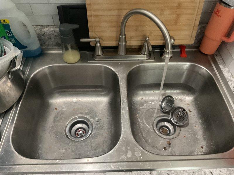 Responded to service call for slow draining kitchen sink. Upon inspection, removed and cleared accumulated debris, hair, and organic material from the drain line. Extracted blockage causing restricted flow in the 2-inch drain pipe. Tested drainage system after clearing obstruction, confirmed proper water flow and drainage restored to both basins of double-bowl sink.