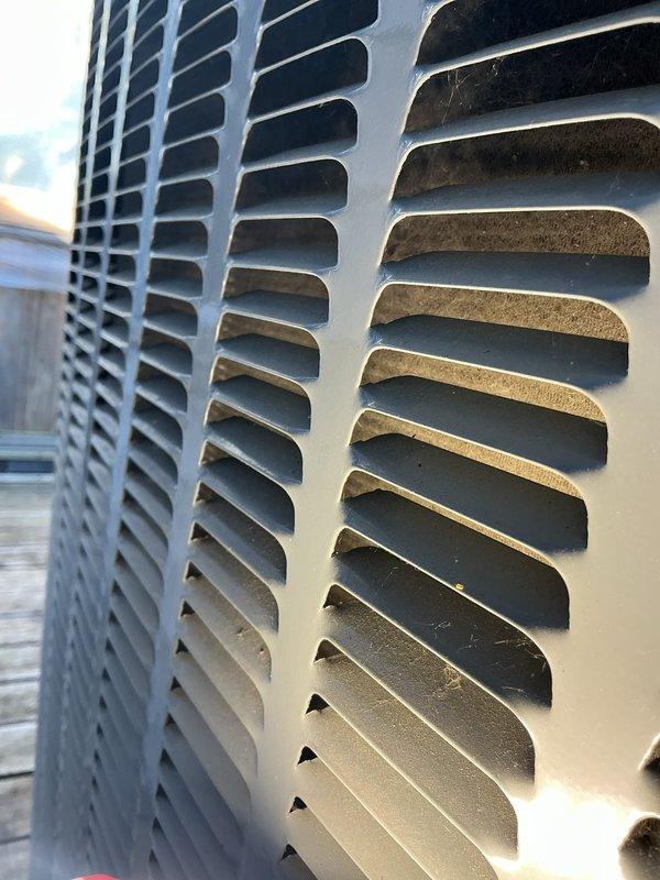 Completed annual cooling maintenance on EnergiAir system including full inspection of condenser unit and indoor components. Observed normal weathering on exterior louvers with minor dust accumulation on coil fins; condensate drain system and associated plumbing connections inspected and found operational. Unit photographed for service records and system confirmed operating within manufacturer specifications.