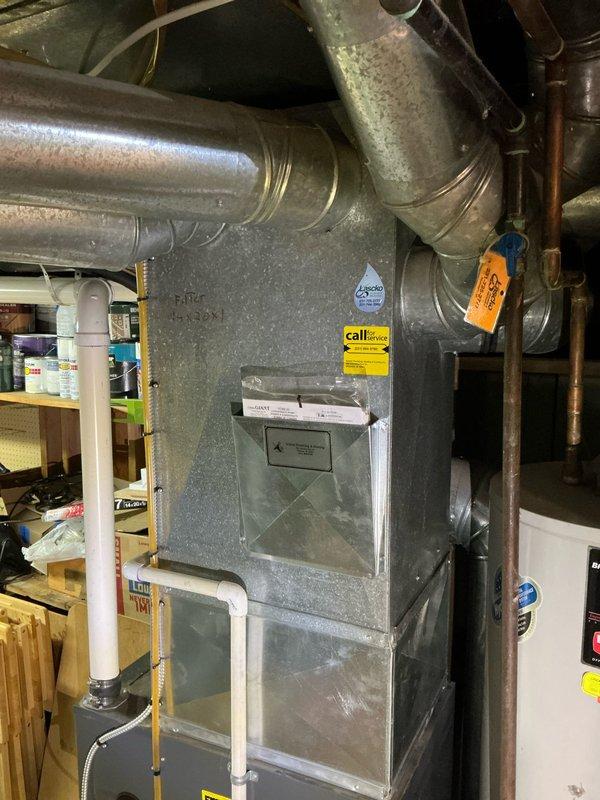 Conducted on-site evaluation for whole home air conditioning system replacement. Existing equipment is 20-25 years old and has reached end of serviceable life. Assessed current HVAC infrastructure in basement utility area, including furnace configuration, ductwork layout, and available installation space. Documented existing system setup with photos showing gray metal furnace unit with connected ductwork, PVC condensate drain line, and electrical connections. Evaluated structural considerations for new equipment placement alongside water heater and existing heating system. Provided comprehensive estimate for complete air conditioning system replacement including outdoor condensing unit, indoor evaporator coil, refrigerant lines, electrical upgrades, and integration with current forced air distribution system.