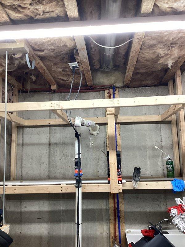 Conducted on-site assessment of existing sump pump system in basement/garage area. Evaluated current installation configuration, discharge piping, and electrical connections. Documented existing conditions with detailed photography showing workspace layout, overhead framing with insulation, concrete block foundation walls, and current equipment positioning. Provided comprehensive estimate for system upgrade or replacement to address operational concerns.