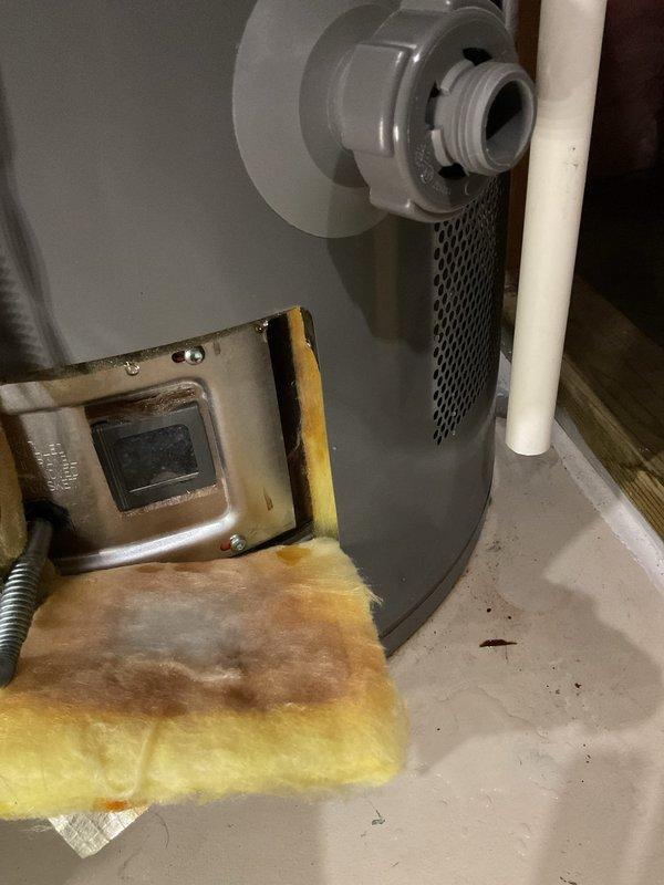 Responded to water heater leak on 4-year-old Rheem ProMaxx unit. Upon inspection, identified active leak at base of water heater with visible rust and corrosion on lower components. Placed bucket to contain leaking water while customer maintained hot water availability. Documented equipment condition with photographs showing water damage and oxidation at leak point. Advised customer of findings and recommended replacement due to extent of corrosion on tank base.