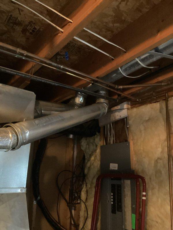 Responded to service call for leaking water heater over 20 years old. Upon arrival, inspected residential water heater located in basement utility area adjacent to furnace system. Identified active leak at plumbing connections and assessed overall condition of unit. Documented equipment age and deterioration through photographic documentation showing water heater installation, surrounding HVAC equipment, and mechanical room configuration. Due to advanced age of unit exceeding typical service life expectancy, recommended replacement rather than repair. Customer opted for cash/check without warranty coverage.