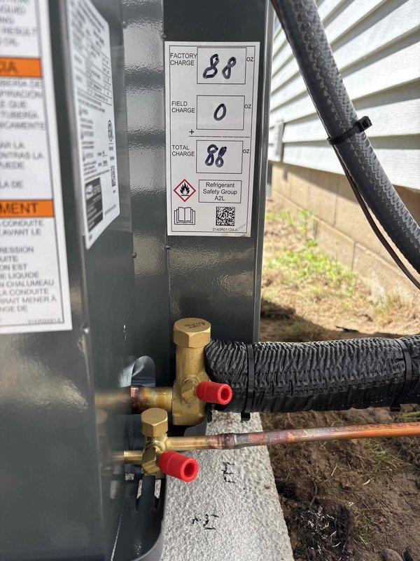 Completed full air conditioning system replacement at residential property. Installed new condensing unit on existing concrete pad with decorative rock bed surround, positioned adjacent to exterior wall with proper clearances. Unit charged with 88 oz refrigerant per factory specifications with no additional field charge required. Connected refrigerant lines with brass service valves and insulated suction line, verified all connections secure and leak-free. System tested and operational, ready for service.