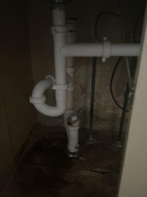 Redirected kitchen drain plumbing by installing new PVC P-trap assembly and drainage piping from the sink connection through the basement ceiling area. Properly secured all pipes with hangers and supports to floor joists, ensuring proper slope and code-compliant drainage to the main waste line.