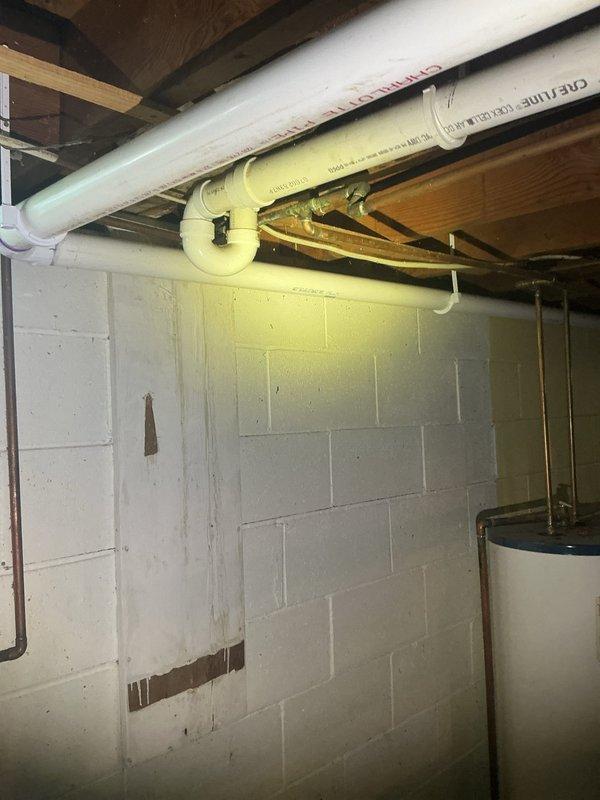 Redirected kitchen drain plumbing by installing new PVC P-trap assembly and drainage piping from the sink connection through the basement ceiling area. Properly secured all pipes with hangers and supports to floor joists, ensuring proper slope and code-compliant drainage to the main waste line.