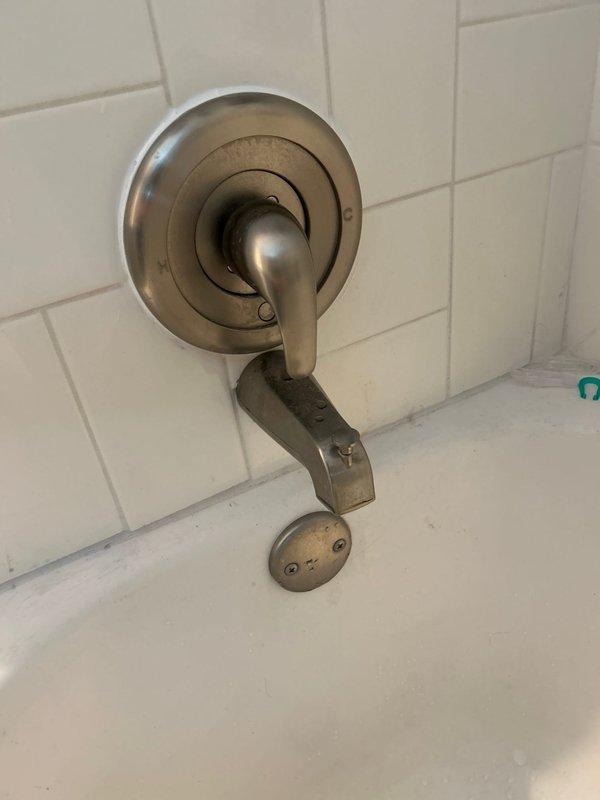 Responded to service call for two plumbing issues: exterior vacuum breaker leaking at irrigation system backflow preventer and noisy downstairs bathtub faucet when operated at certain temperatures. Inspected exterior sprinkler system vacuum breaker assembly mounted on brick wall, which had been leaking since previous spring season. Evaluated backflow prevention device, pressure relief valve, and associated piping connections for signs of failure or deterioration. Examined downstairs bathtub fixture including spout, diverter control, and faucet assembly on tiled wall for source of temperature-related noise issue that had persisted since installation. Documented condition of both fixtures with photographs showing weathered exterior plumbing components with surface corrosion and aged bathroom hardware with water staining. Provided assessment and recommendations for repair or replacement of affected components to resolve ongoing leak and noise concerns at both isolated fixture locations.