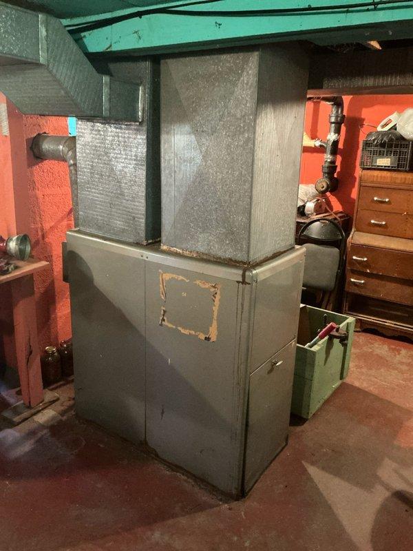 Completed furnace replacement estimate for residential property with aging HVAC system located in basement utility area. Assessed existing furnace unit showing visible wear and discoloration, documented current ductwork configuration including metallic supply ducts and flexible duct connections to air handler, and evaluated installation requirements for new equipment replacement. Customer is obtaining multiple estimates for comparison before making final decision on system upgrade.
