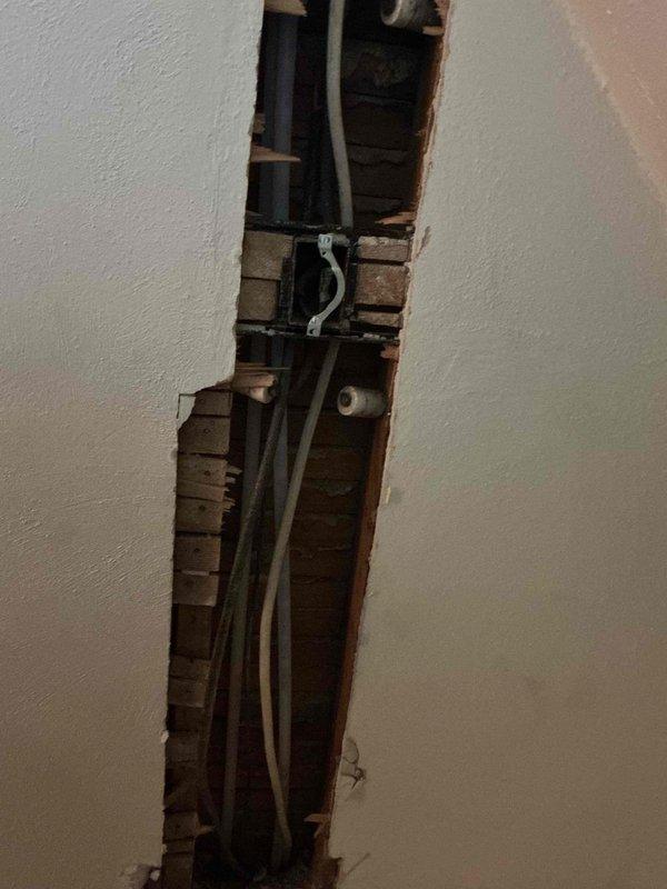 Completed partial repipe of residential plumbing system, installing new hot and cold water supply lines in basement utility area. Work included running new PEX piping (red for hot water, blue for cold water) with proper mounting brackets and securing all lines to structural members. Created wall access points through drywall to route new supply lines through existing wall cavities, working around existing electrical conduits and framing. All new pipe connections were properly fitted with appropriate fittings and tags for system identification.