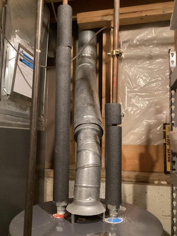 Conducted water heater replacement estimate for existing AO Smith unit located in basement utility area. Assessed current installation including copper supply lines with foam insulation sleeves, vertical venting system, and connections to existing plumbing infrastructure. Documented mechanical space configuration with exposed framing and provided recommendations for replacement equipment and installation requirements.